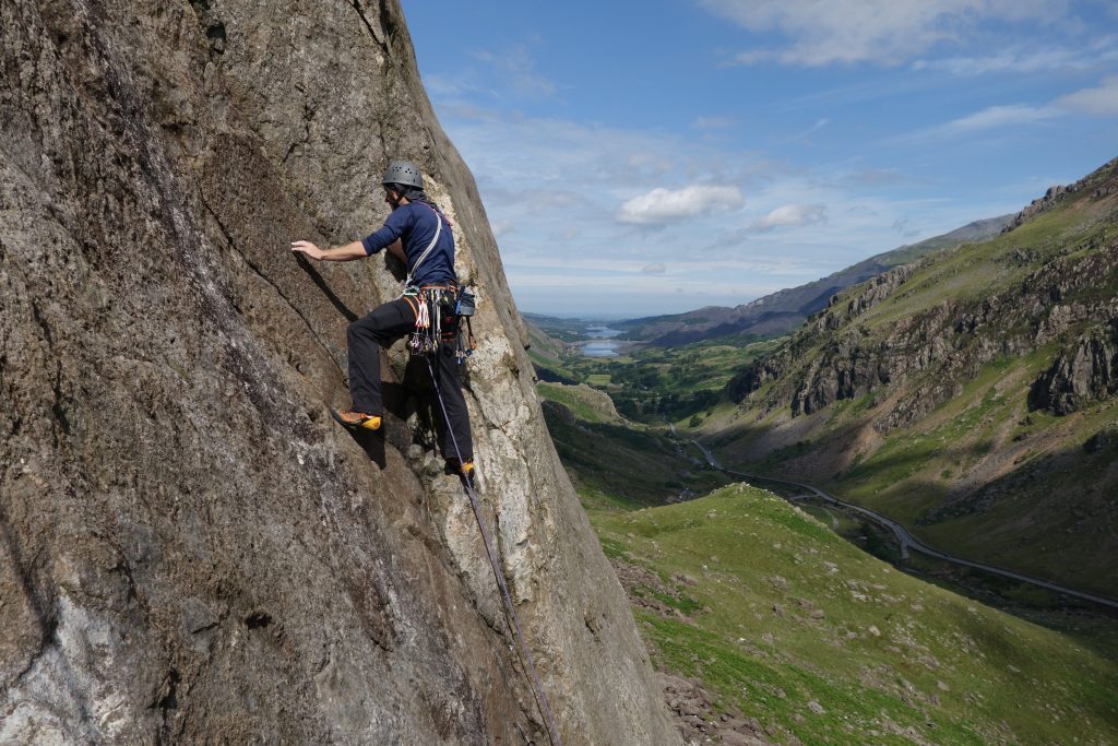An early start lets you catch the morning sun on the Eastern Flanks of the Nose of Dinas Mot with the spectacular view down the valley only adding to the atmosphere of great climbing. Here Adam Riches enjoys the first pitches of Direct Route (VS) on Dinas Mot.