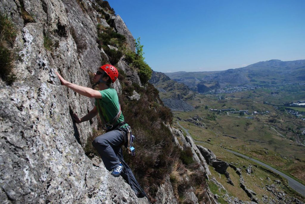 A climber eyeing up the final moves on Slick, Severe, Clogwyn Yr Oen, Moelwyns
