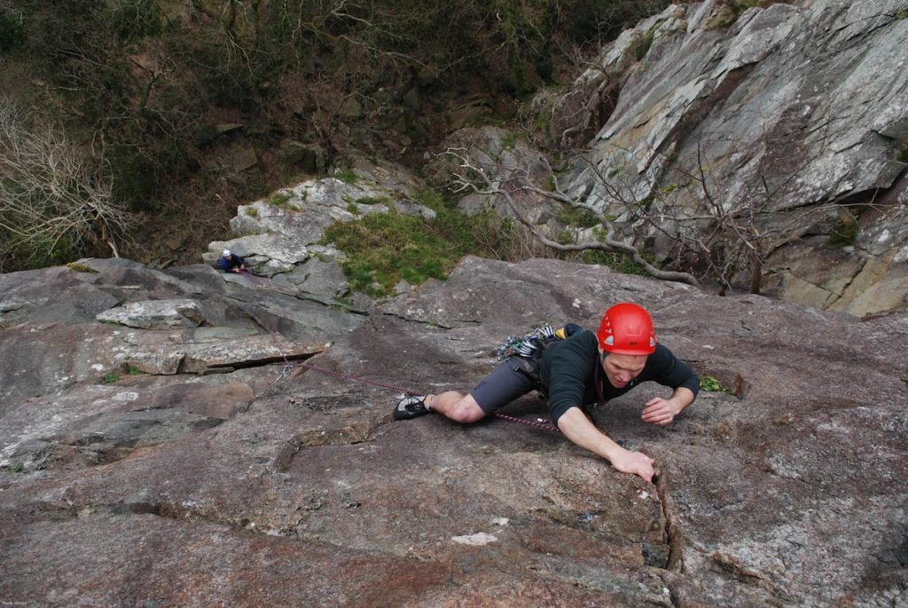 George getting his gear in and head together as he faces up to the final crux crack of Merlin Diorect on a Lead Climb Coaching Courses.