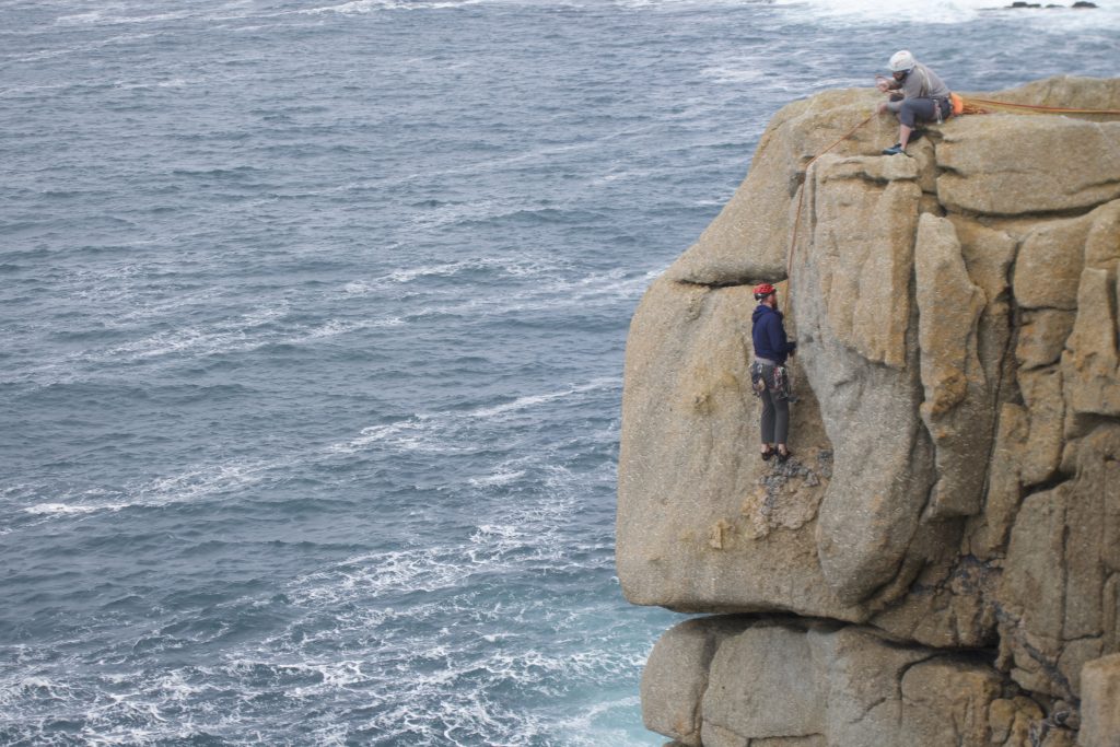 An unkown climber in the off width section of Demo Route, Sennen, Cornwall.